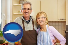north-carolina map icon and a senior couple standing in their apartment kitchen