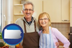 pennsylvania map icon and a senior couple standing in their apartment kitchen
