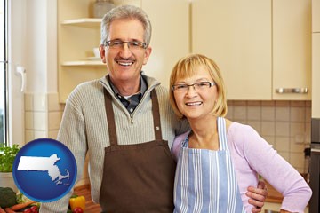 a senior couple standing in their apartment kitchen - with Massachusetts icon