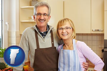 a senior couple standing in their apartment kitchen - with Vermont icon